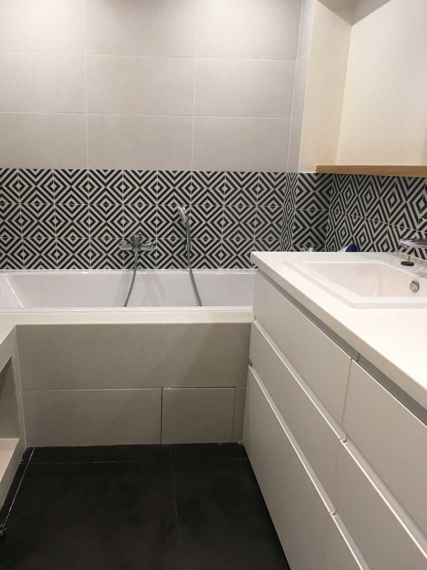Salle de bain avec baignoire et frise de carrelage géométrique — rénovation Paris