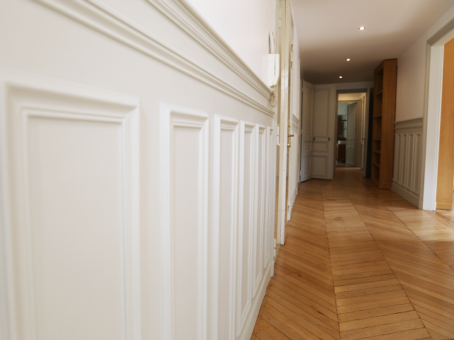 Couloir avec soubassement et moulures blanches — rénovation Paris