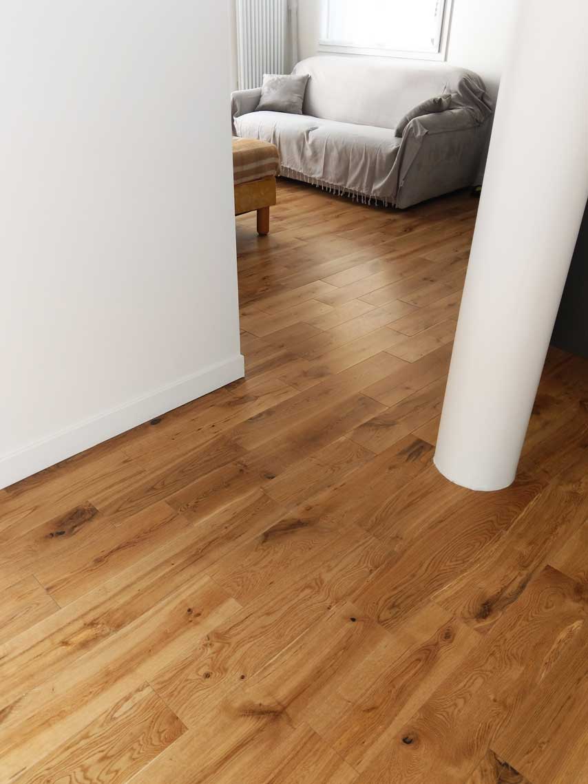 Séjour avec parquet en chêne et colonne blanche — rénovation Paris