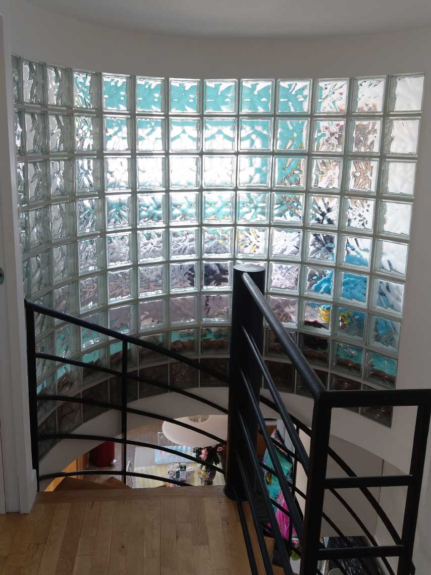 Escalier avec garde-corps en verre et mur de briques — rénovation Paris